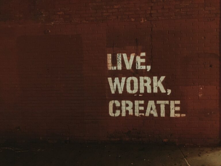 A brick wall with "live, work, create" painted on it